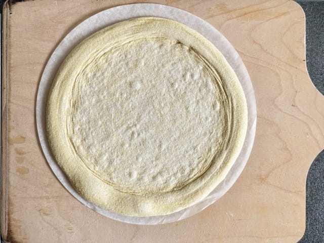 Pizza ausbreiten auf dem Brotschieber vor dem Belegen.