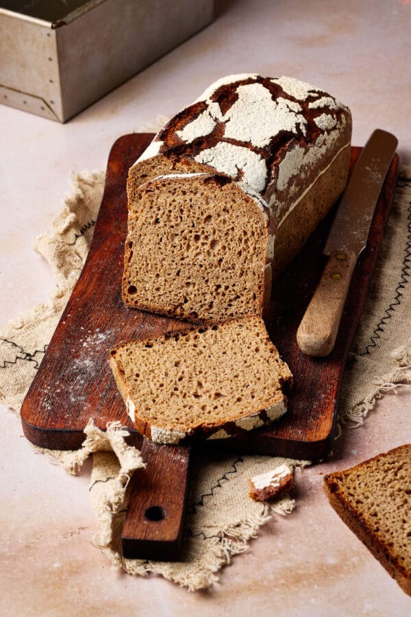 Reines Roggenbrot mit Sauerteig aufgeschnitten auf einem rustikalen Holzbrett.