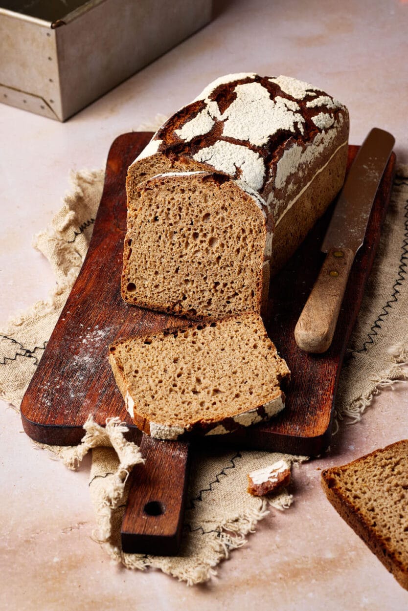 Reines Roggenbrot mit Sauerteig aufgeschnitten auf einem rustikalen Holzbrett.