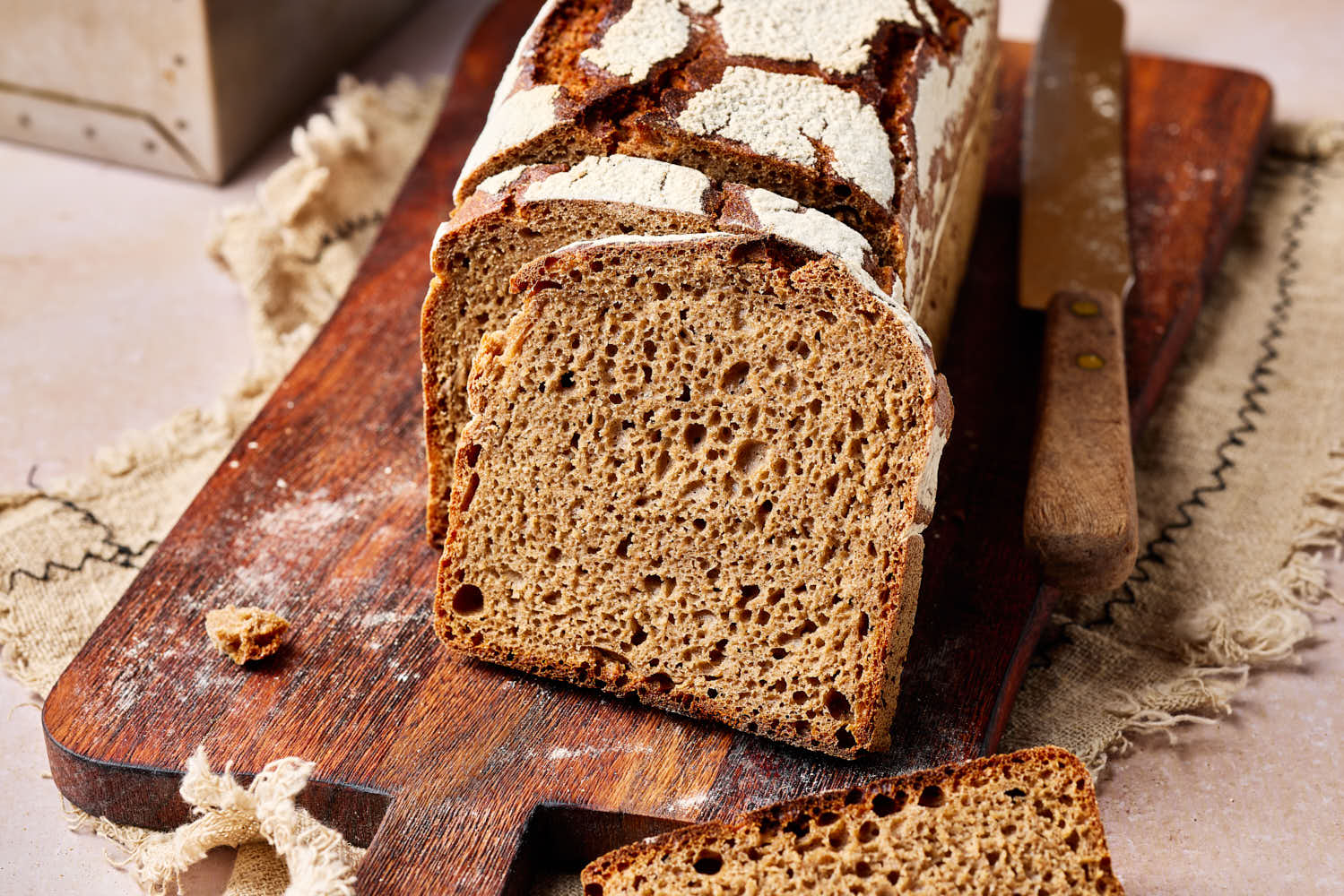 Reines Roggenbrot mit Sauerteig aufgeschnitten auf einem rustikalen Holzbrett.