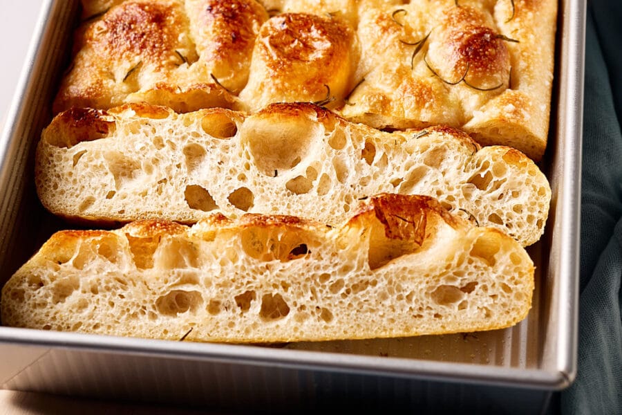 Luftige, angeschnittene Focaccia mit Sauerteig in eine Backform.