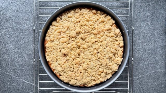 Apfelkuchen mit Streusel beim Auskühlen auf einem Rost.