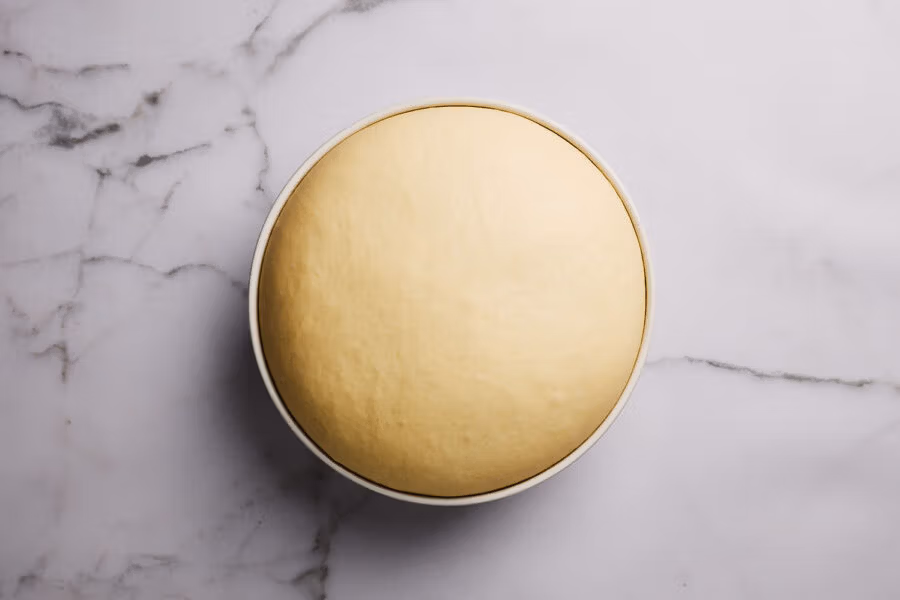 Gereifter Hefeteig in einer Keramikschüssel.