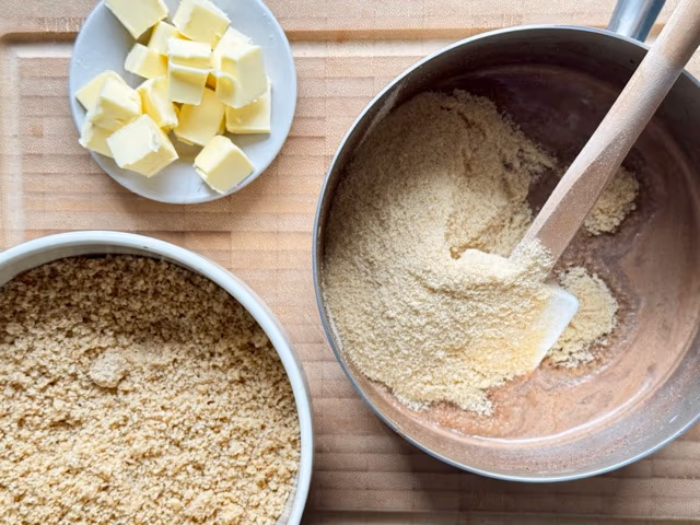 Löffelbiskuit und Nüsse in die heiße Milch für Nussfüllung rühren.
