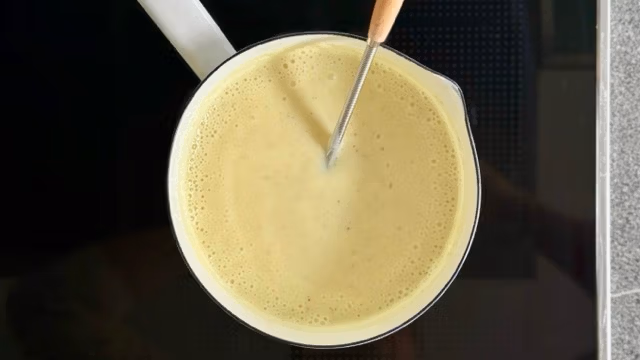 Selbst gemachte Vanillesoße auf dem herd aufkochen.