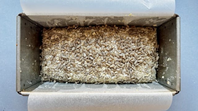 Teig für Eiweißbrot mit Quakr in einer mit Backpapier ausgelegten Kastenform.