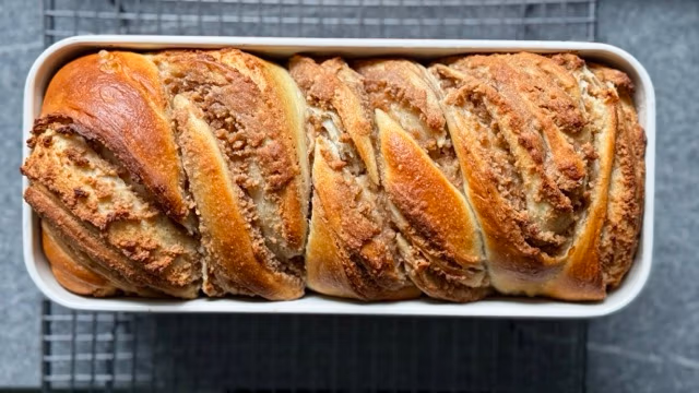 Frisch gebackener Nusszopf auf einem Rost.