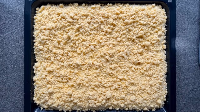 Streuselteig auf dem Hefeteig verteilt.