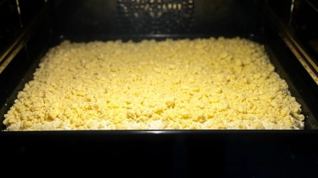 Saftiger Hefe-Streuselteig vom Blech im Backofen.