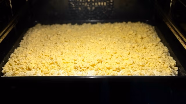 Saftiger Hefe-Streuselteig vom Blech im Backofen.