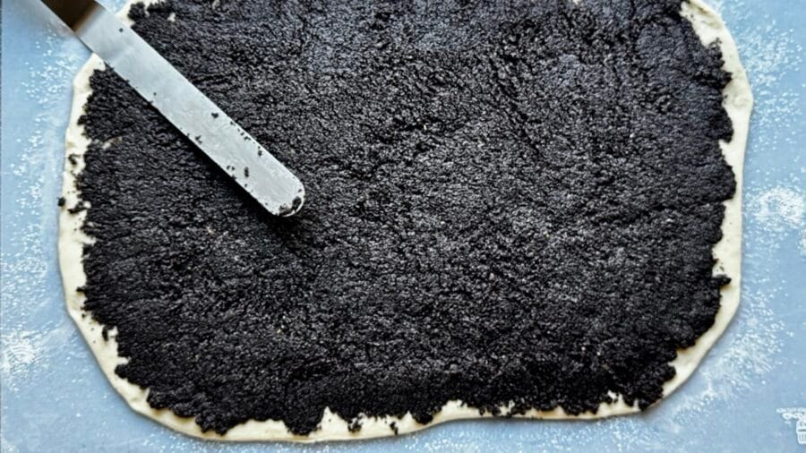 Mohnfüllung auf Hefeteig streichen.