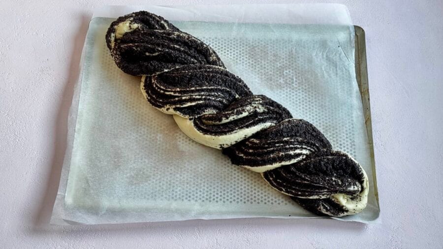 Geflochtener Mohnzopf auf einem Backblech.