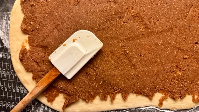 Nussfülllung auf dem Hefeteig verstreichen.