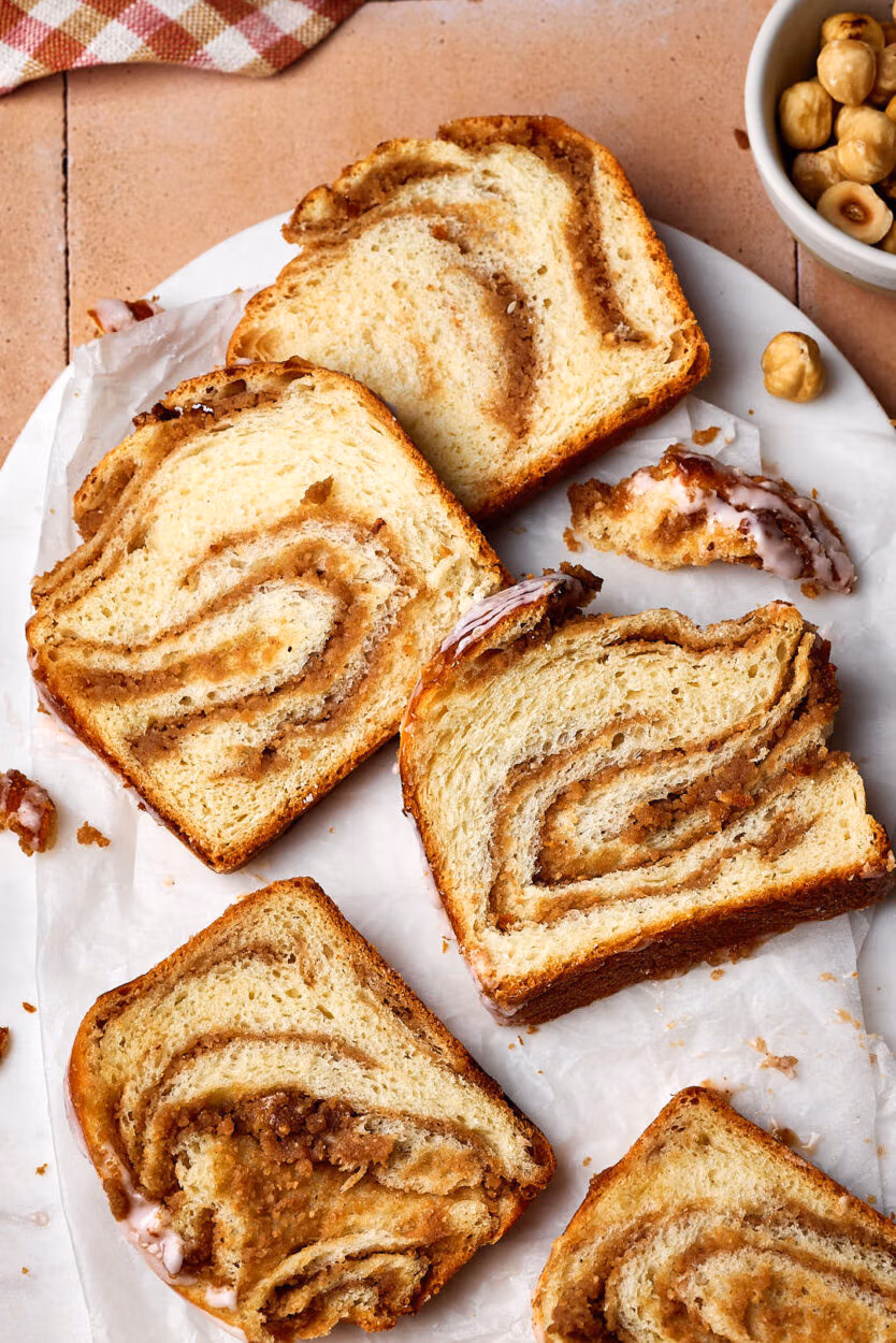 Saftiger Nusszopf in Scheiben geschnitten auf einem Marmortablett.