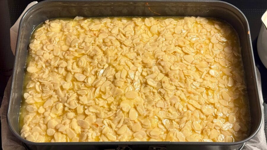 Mandeltopping auf dem Teig verteilt für Butterkuchen ohne Hefe vom Blech.