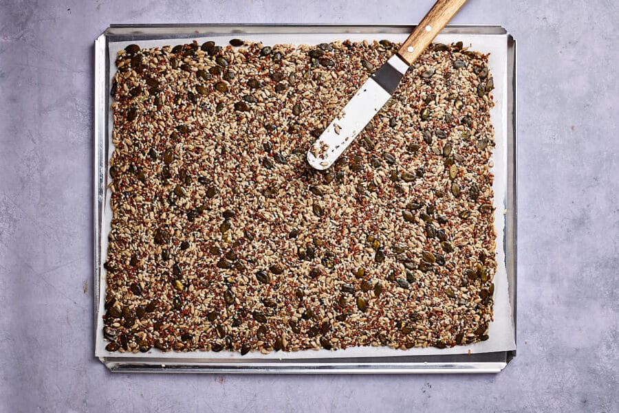 Ausgestrichene Saatenmasse auf einem Backblech vor dem Backen.