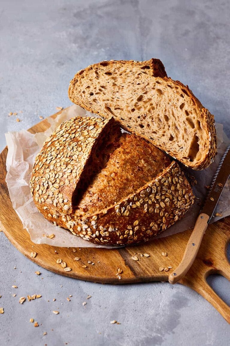 Dinkelbrot backen: aufgeschnittenes Dinkelbrot mit goldbrauner Kruste und lockerer Krume auf einem Holzbrett.