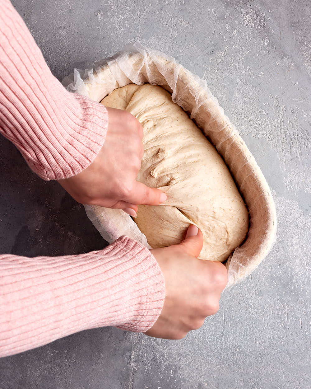 Nachstraffen (Stitching) des Sauerteigbrot-Teiglings im Gärkörbchen zu Beginn der Stückgare. 