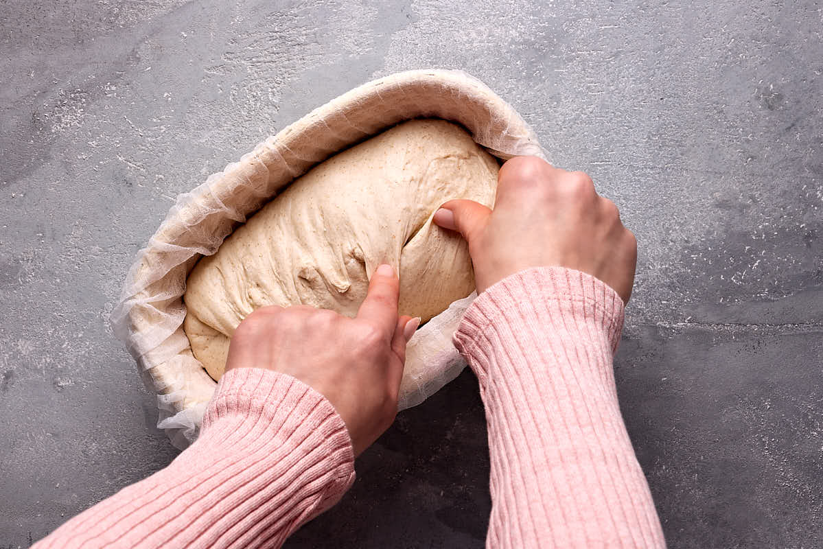 Nachstraffen im Gärkörbchen von Sauerteigbrot zu Beginn der Stückgare.