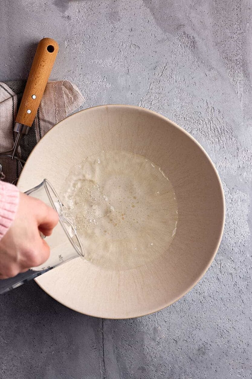 Vorbereitung der Teigzutaten in der Backstube: Abmessen der Schüttflüssigkeit für die exakte TA-Berechnung beim Brotbacken.
